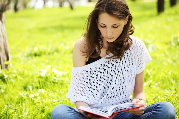 Imagen de una joven hermosa en el parque de verano leyendo un libro —  Fotos de Stock