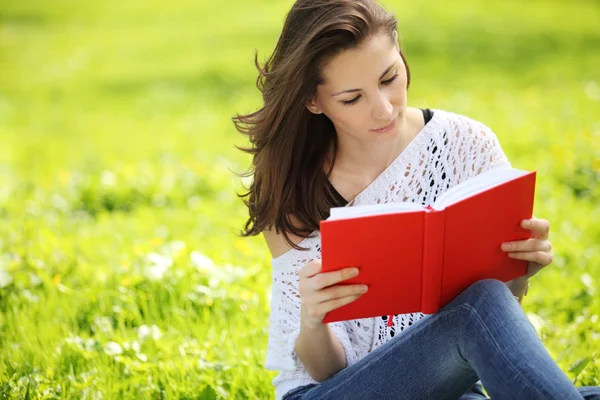 年轻漂亮的女人在夏天公园读一本书的图像 — 图库照片