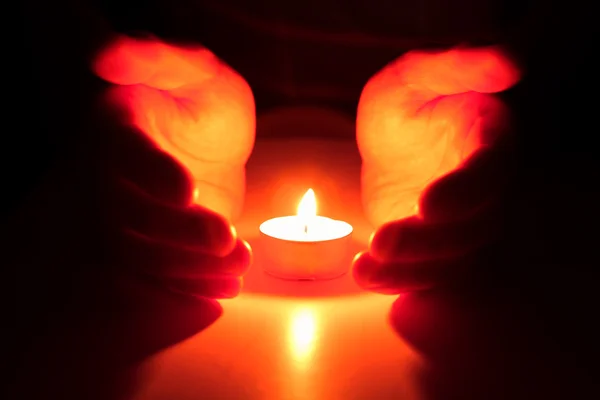 Mâinile bătute în jurul unei lumânări — Fotografie, imagine de stoc