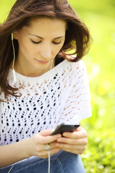 Bild einer jungen schönen Frau im Sommerpark, die eine Nachricht liest — Stockfoto