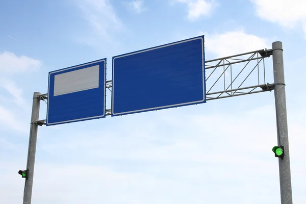 Image of blue road sign with green traffic lights on — Stock Photo, Image