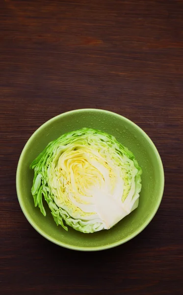 Зображення білої капусти в глибокій тарілці над дерев'яним тлом — стокове фото
