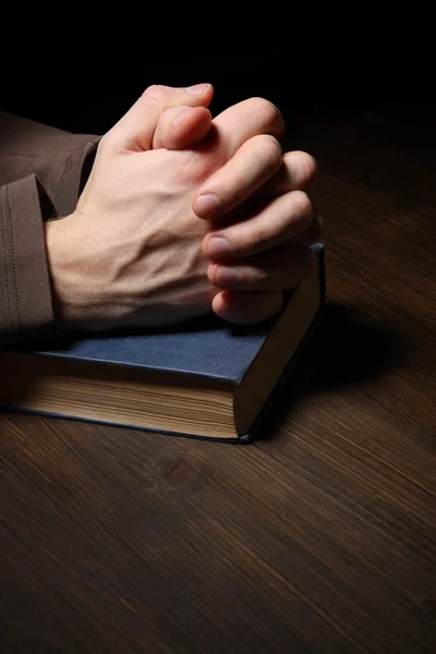 Hands folded in prayer over a Holy Bible — Stock Photo, Image