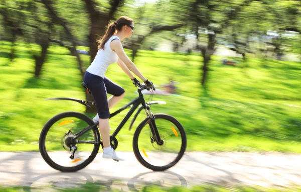 Красива жінка з велосипедом в зеленому парку — стокове фото