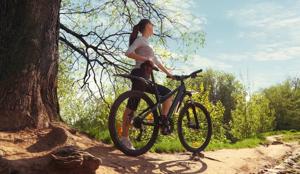 Жінка з велосипедом у парку — стокове фото