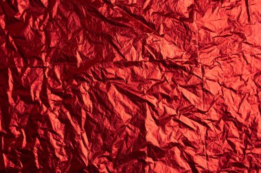 Kırmızı tonda, buruşmuş gümüş alüminyum folyo dokusunun yakın çekimi. Soyut arkaplan, tasarım için kullan