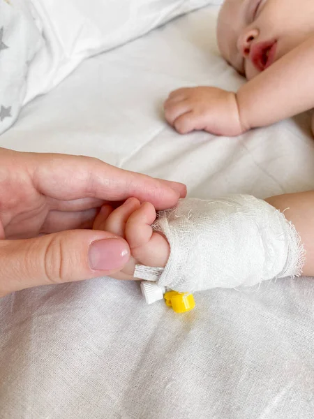 Mother holding childs hand who fever patients in hospital to give encouragement.