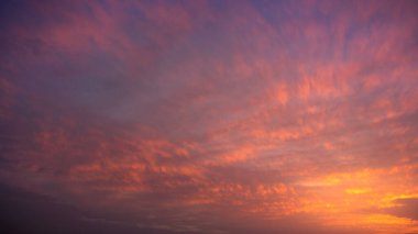 Kümülüs bulutlarının harika manzarası yazın günbatımında turuncu güneş ışığıyla gökyüzü. Gün batımında doğa arkaplan manzarası gibi güzel bulutlar. Doğal gün ışığı havası Altın güneş ışığı
