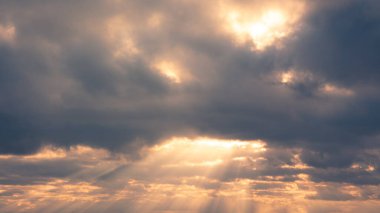 Kümülüs bulutlarının harika manzarası yazın günbatımında turuncu güneş ışığıyla gökyüzü. Gün batımında doğa arkaplan manzarası gibi güzel bulutlar. Doğal gün ışığı havası Altın güneş ışığı
