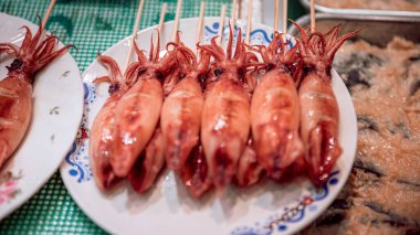 Küçük ızgara kalamar, Japon yemeği ve mutfağını kapatın. Çubuklardaki küçük ahtapot Kyoto 'daki deniz ürünleri dükkanında lezzetli geleneksel Japon sokak atıştırmalıkları. Satılık balık pazarı