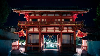 Yasaka Jinja Tapınağı 'nın gece ziyaretçileriyle dolu büyük kapısı ve giriş binası. Gion Tapınağı Kyoto 'daki en ünlü tapınaklardan biridir.