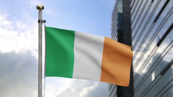 アイルランドの旗は現代の超高層ビル街と風に揺れる アイルランドのバナーを吹いて 柔らかく滑らかなシルクを閉じます 布生地の質感が背景を刻印 国民の日と国の行事の概念 — ストック動画