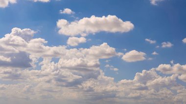 Güneşli bir yaz gününde mavi gökyüzü olan kümülüs bulutları. Doğa arkaplan manzarası olarak güzel bulutlar. Beyaz bulutların yüzdüğü, soyut bir şekil oluşturan doğal gün ışığının harika havası.