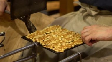 Japonların bol badem ve tereyağlı çıtır bademli kurabiyeleri nasıl yaptığını yavaş çekimde. Sıcak metal tabakta Brittles bisküvileri dilimlenmiş. Fırınsız ev yapımı kek..