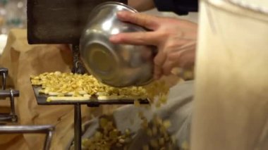 Asyalı adamın ağır çekimde pişirdiği yemek tarifi sıcak masada tatlı oluyor. El yapımı endüstriyel kurabiye makinesi. Çıtır bademli tatlı Japonya 'da popüler bir sokak abur cuburudur.