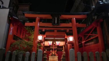 Kyoto, Japonya-12 Nisan 2019: Kyoto 'daki Inari Tapınağı' nda nöbet tutan antik taş tilki. Torii genellikle bir tapınakta bulunan geleneksel bir Japon kapısıdır. Tarihi turistlerin ilgi odağı