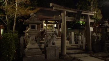 Kyoto, Japonya-12 Nisan 2019: taş torii kapısı ve geceleri Yasaka Jinja tapınağında sunak. Gion Tapınağı Kyoto 'da ünlü bir tapınak. Eski Tori girişi olan Japon Tochigi şehir merkezi.