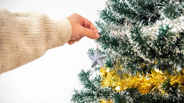 メリークリスマスと幸せな休日 男の手は冬に屋内にトウヒの木を飾ることです Xmas星装飾バナーのモミの枝のぶら下げ 新年のコンセプト — ストック写真