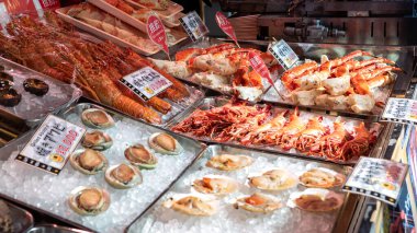 Tokyo, Japonya-03 Şubat 2020: Tsukiji balık pazarında yengeç bacağı ve deniz ürünleri satan tüccarlar. Tokyo 'da perakende satış yapan büyük bir balık ve deniz ürünleri pazarı. Suşi siparişi gecikmiş.