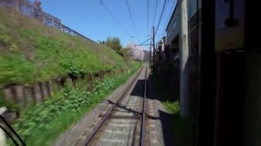 Japon Kyoto yerel treni bahar mevsiminde demiryolu boyunca demiryolu üzerinde seyahat ediyor. Demiryolu ve tren manzarası manzara geziyor. Japonya 'yı gezmek için taşıma