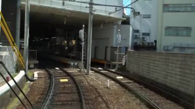 Kyoto, Japonya-13 Nisan 2019: Japon yerel treni ilkbahar mevsiminde demiryolu boyunca tren rayları üzerinde seyahat ediyor. Demiryolu ve tren manzarası manzara geziyor. Japonya 'yı gezmek için taşıma