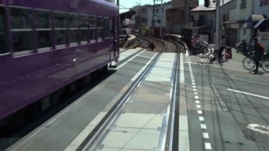 Kyoto, Japonya-13 Nisan 2019: Japon yerel treni ilkbahar mevsiminde demiryolu boyunca tren rayları üzerinde seyahat ediyor. Demiryolu ve tren manzarası manzara geziyor. Japonya 'yı gezmek için taşıma