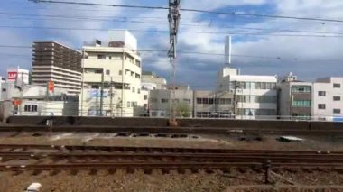 Kyoto, Japonya-12 Nisan 2019: Mavi gökyüzü ile güzel bir günde, tren seferi sırasında pencereden şehir manzarası. Tren istasyonundan kalkan trenler. Ev yapımı Japon caddesi