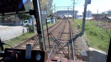 Kyoto, Japonya-13 Nisan 2019: Japon yerel treni ilkbahar mevsiminde demiryolu boyunca tren rayları üzerinde seyahat ediyor. Demiryolu ve tren manzarası manzara geziyor. Japonya 'yı gezmek için taşıma