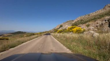 İspanya 'nın güneyindeki Malaga vilayetlerindeki bir dağın içinden iki yönlü eski asfalt yolda giden araba POV' u. Endülüs 'te dağları olan bir İspanyol kırsal bölgesinden geçmek..