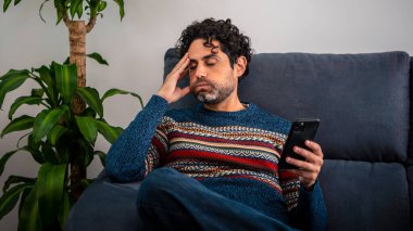 Kanepede baş ağrısı çekerken alnını tutan bir erkek bunalımı. Yetişkin bir adam akıllı telefon kullanır, düşünür, ağır düşünür, sevgilisinden ayrılır ya da maddi sorunlar yaşar.