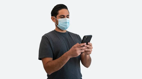 Man Använder Smartphone Och Ansiktsmask Säker Från Coronavirus Isolerad Vit — Stockfoto