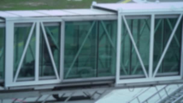 焦点を空気で旅をぼやけている ジェットウェイを通ってスチュワーデス搭乗し 飛行する飛行機に入る ジェットブリッジの中を歩く 飛行機への空港ターミナルトンネル — ストック動画