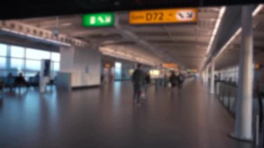 Uluslararası Havalimanı 'nda yolcu ve hostes yürüyüşlerinin odak noktasından çıkarılmış görüntüsü. İnsanlar terminalin kapısında uçmak için yürüyorlar. Avrupa havaalanları. Sahnede bulanık arkaplan