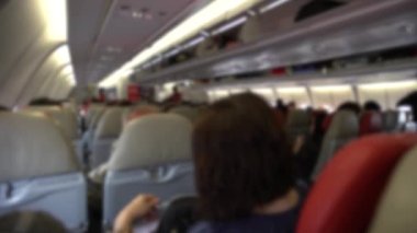 Yolcularla dolu bulanık iç uçak koltukları, koltuktan yolcu olarak bir uçağa binen yolcular olarak bakış açısı. Uçağın arka görüntüsü.