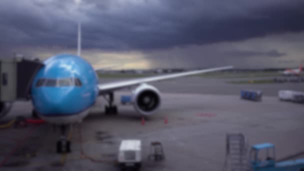 雨の日に焦点を当てた飛行機を爆破した 航空機は 背景に暗い雨の雲とターミナルビルの近くの国際空港にあります 休暇旅行のコンセプト — ストック動画