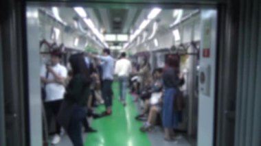 Bulanık, bulanık, Koreli bir insan metroda seyahat ediyor, akıllı telefon kullanıyor ve metroda konuşuyor.