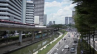 Yükseltilmiş trenin odaksız görüntüsü dış gün caddelerdeki trafik arabalarıyla bir hat üzerinde seyahat ediyor. Modern metro sistemine sahip şehir manzarası. Metro şehri işe gidiş gelişi. Sahnede bulanık arkaplan