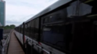 Bulanık, odağını kaybetmiş. Yükseltilmiş bir tren bir hat üzerinde ilerliyor. Modern metro sistemi istasyona ulaşan şehir manzarası. Metro şehri işe gidiş gelişi. Asya 'da demiryolu seyahati.