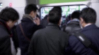 Bulanık Asyalı bir kalabalık metroda trafiğin en yoğun olduğu saatte hareket ediyor. Tren istasyonunda bir sürü yolcu vardı. Japon gezginler iş için metroya binerler.