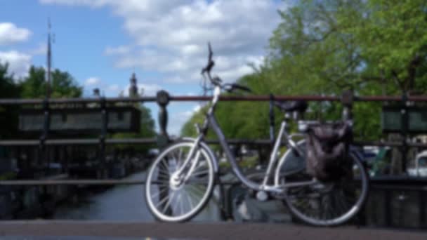 アムステルダムの運河の橋の上に駐輪された自転車の専用ショット 自転車通りの運河の横に立っている オランダの街並み 自転車輸送 — ストック動画