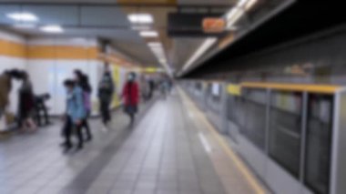 Asyalıların cerrahi maske takıp tren istasyonunda yürürken çekilmiş görüntüleri. Koruyucu maskeler korona virüsü enfeksiyonu riskini azaltır. COVID-19 metroda bulaşıcı