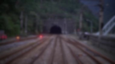 Tayvan 'ın dağlarındaki bir kırsal bölgedeki istasyondaki bir tünelden gelen rayların odaklanmış görüntüsü. Traveling Rails transit yolculuğu. Gezginler yolculuk için trenlere biner.