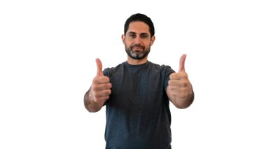 Beyaz arka planda duran beyaz bir adam baş parmağını gösteriyor. Kameraya bakan bir kişinin portresi. Yakışıklı erkek model..