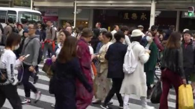 Kyoto, Japonya-13 Nisan 2019, kalabalık yaya geçidi. Asyalı insanlar ve turistler en kalabalık yaya geçidinde yürüyorlar. Japon iş adamları ve kadınlar kavşağı geçtiler.