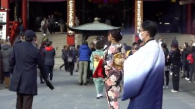 Tokyo, Japonya-03 Şubat 2020: Budist Sensoji Tapınağı 'nda geleneksel kimono duası yapan Japon kadınlar. Asakusa şehrinin en eski ve en önemli tapınakları. Yurtiçi seyahat kültürü.