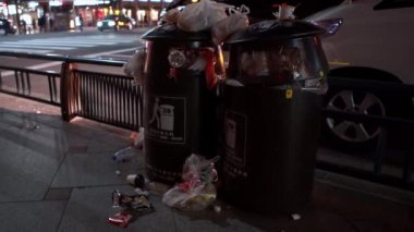 Kyoto, Japonya-12 Nisan 2019: Şehir caddesinde çöp dolu iki siyah çöp kutusu. Yaya yoluna çöp yığını. Birçok kirlilik çöpü ve plastik taşan konteynır ve zemini kirletiyor