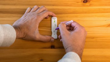 İnsan, evdeki koronavirüsü tespit etmek için numuneyi tampon damlatıcıya yerleştiriyor. Kalabalıktan döndükten ve insanlarla tanıştıktan sonra PCR testi. Karantina salgını.