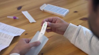 Evde Coronavirus test kitini açan adamın elleri. Hızlı test evinizde yapılabilir ve Covid19 sonuçları 15 dakika içinde alınabilir. İlaç, karantina ve salgın konsepti