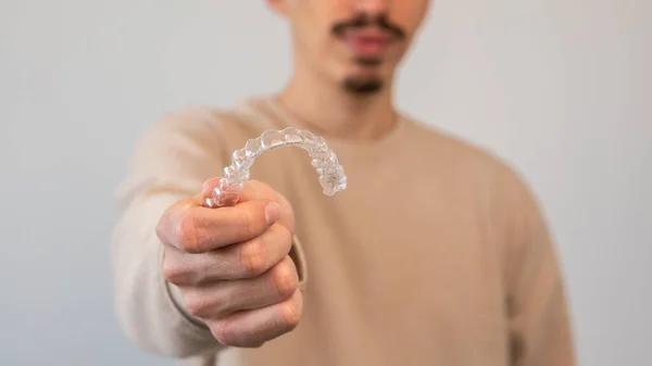 Biały Młodzieniec Pokazuje Niewidzialny Silikonowy Korektor Zębów Mężczyzna Ręka Trzymając — Zdjęcie stockowe