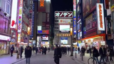 Tokyo, Japonya-02 Şubat 2020: Asyalılar geceleri Shinjuku bölgesinde renkli reklam panolarıyla sokakta yürüyorlar. Gece yaşamında uykusuz kasaba olarak bilinen restoranları ve gece kulüpleri olan ünlü barlar.